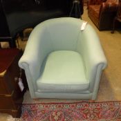 A deep low tub chair upholstered in duck egg blue fabric, on pine feet.