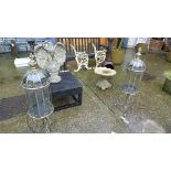 A pair of wrought iron garden lanterns on stands