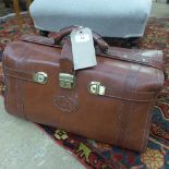A brown leather gladstone bag
