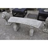A reconstituted stone garden bench of Florentine design