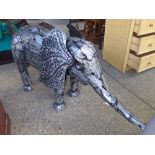 A polished metal garden elephant