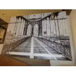 A large black and white photo on board of Brooklyn Bridge in New York