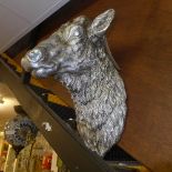 A faux silver plate model of a rams head.