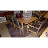 A Gordon Russell walnut dining suite comprising extending table and six chairs