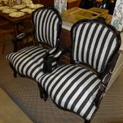 A pair of contemporary ebonised fautieuls upholstered in striped fabric