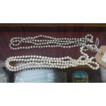 A pair of silver and white faux pearl necklaces
