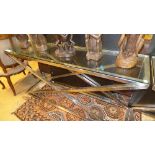 An x - framed contemporary chrome console table with glass top (75 x x150 x 40)