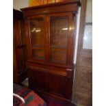 A Victorian mahogany bookcase having pair of glazed doors above drawer and cupboards on plinth