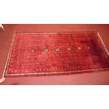 A fine North East Persian Turkoman rug 244cm x 125cm diamond and geometric motifs on a rouge field