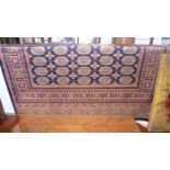 A Bokhara style rug with repeating motifs on a navy field surrounded by running borders 190x 140cm