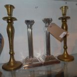 A pair of silver plated Corinthium column form candlesticks and a brass pair