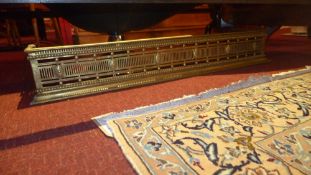 A Georgian brass fender with pierced detail together with a Chinese pottery stool (2)