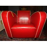 A contemporary Jean Renoir design red faux leather armchair of angular form with ivory piped detail