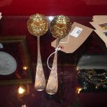 A pair of Edwardian hallmarked silver berry spoons with ornate floral decoration