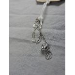 A 18ct white gold doughnut form pendant set single diamond on a fine link chain