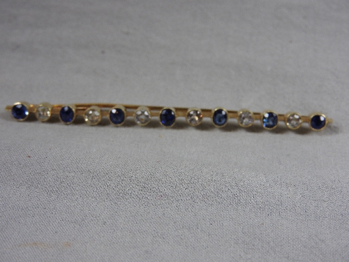 An C18th yellow gold bar brooch set alternating blue and white sapphires.