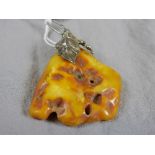 A 20th Century Oriental white metal mounted amber pendant (approx 16grams)