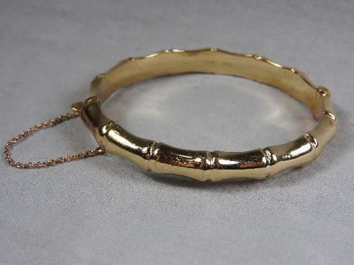 A 9ct gold bangle with bamboo effect detailing.