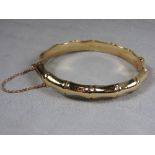A 9ct gold bangle with bamboo effect detailing.