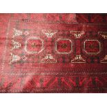 A fine North East Persian Turkoman woollen rug with repeating elephant foot motifs on rouge field