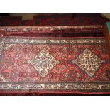 A fine North West Persian Malayer runner triple diamond ivory floral medallion on a rouge field