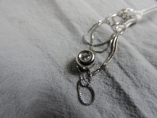 A 18ct white gold doughnut form pendant set single diamond on a fine link chain - Bild 6 aus 6