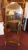 A 1920s walnut cheval dressing mirror with a shaped bevelled plate