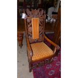 A late 19th century Victorian walnut throne chair/armchair with carved top rail above pad back and