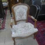 A 20th Century French design beechwood fauteuil upholstered with needlework back and seat on