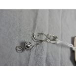 A 18ct white gold doughnut form pendant set single diamond on a fine link chain