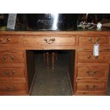 A C20th Victorian design pine pedestal desk/writing table, the green tooled leather above an