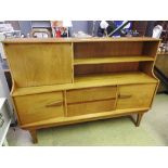 A 1970s G-plan style teak cabinet/sideboard, the upper shelf above two drawers flanked by cupboard