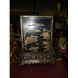 A late 19th Century Chinese Chinoiserie decorated firescreen the black laquered panel with relief