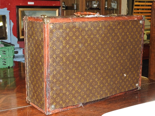 A Louis Vuitton leather traveller case with monogrammed detailing and tan leather bordering and