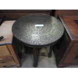 An Indian circular brass topped table on teak stretchered supports 60 cm (d) 66cm (h)
