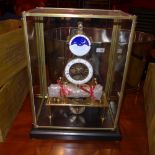 A brass skeleton clock with enamel dial