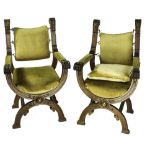 A PAIR OF BARONIAL STYLE 'X' FRAME ARMCHAIRS, each with carved detail, upholstered seats and