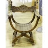 A COLONIAL HARDWOOD 'X' FRAME ARMCHAIR, decorated with heraldic lion decoration to the back and