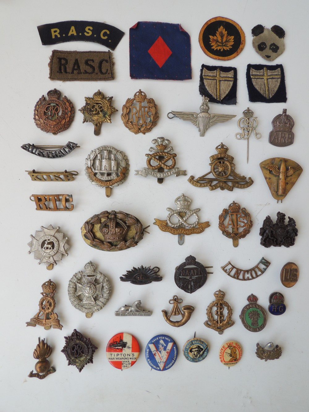 A COLLECTION OF MILITARY BADGES AND CLOTH INSIGNIA, to include 'NAFFI', 'RASC', Women's Land Army,