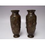 A PAIR OF JAPANESE BRONZE VASES, with relief decoration depicting a bird amongst flowers and