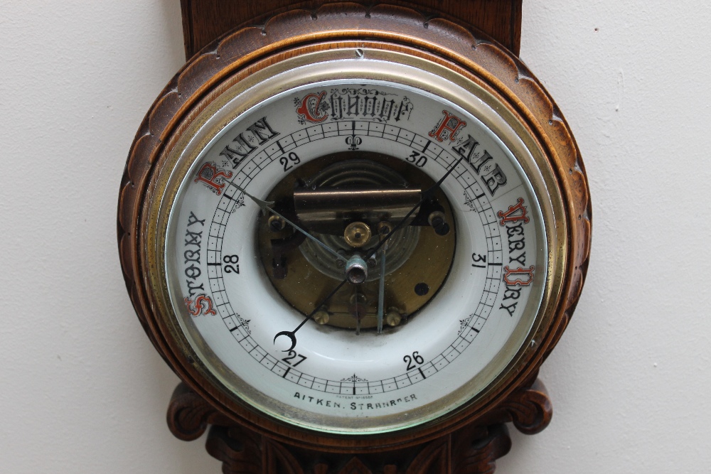 AN EARLY 20TH CENTURY OAK CARVED ANEROID BAROMETER, of Gothic style, carved with half turned - Image 2 of 3