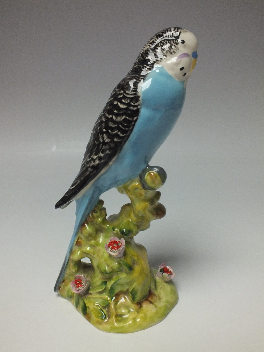 A BESWICK BUDGERIGAR MODEL 1217, first version, facing right, designed by Arthur Gredington, flowers