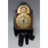 A LATE 18TH CENTURY FOUR PILLAR BRASS FACE WALL CLOCK, the 6" arched dial with cherub masks and