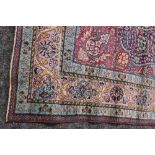 A LARGE EASTERN WOOLLEN RUG, with an all over floral design on a red and blue ground, 323 x 230 cm