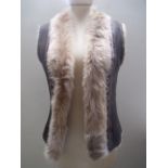 A RETRO 1970S STYLE FUR LINED GILET, the leather look outer with applied and stitched embellishment,