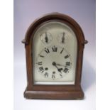 AN OAK CASED QUARTER STRIKING DOMED MANTEL CLOCK, steel face with Roman numerals, two subsidiary