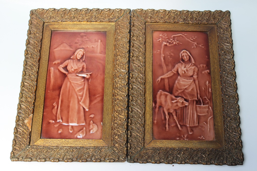 A PAIR OF FRAMED VICTORIAN MAJOLICA PANELS, decorated in brown relief with farmer's wives feeding