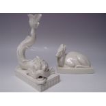 A WEDGWOOD WHITE GLAZED DOLPHIN CANDLESTICK, the tail forming the sconce, raised on a rectangular