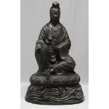 Sitzende Guanyin.Bronze, schwarz patiniert, teils vergoldet. Auf Lotusthron sitzend, in der re. Hand