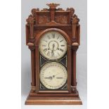 Uhr mit Kalendarium "Waterbury Clock Co.".Architektonisches Holzgehäuse mit Kerbschnitzereien und